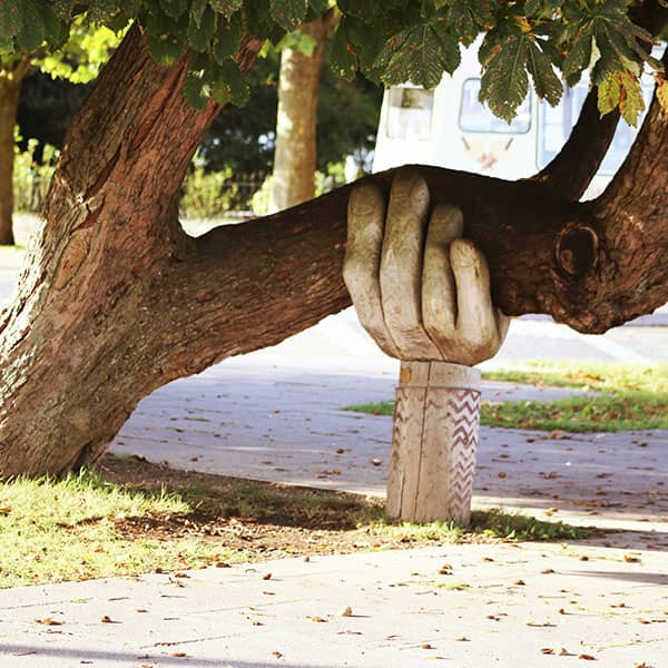 Hand sculpture holding up tree
